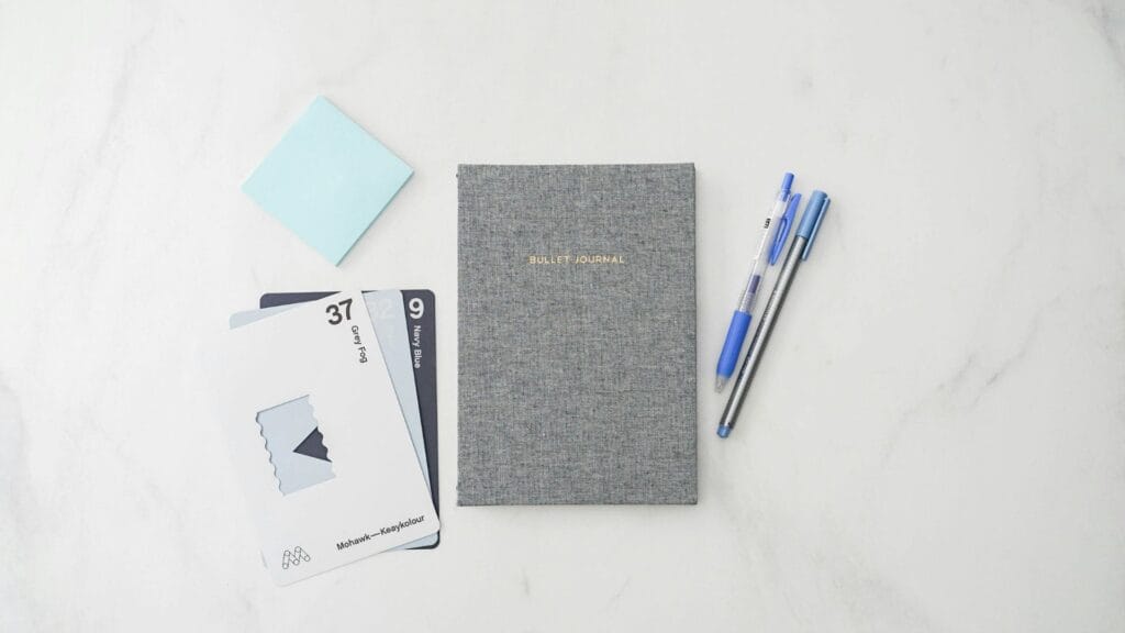 A simple notepad and pen on a desk. Photo by 2H Media