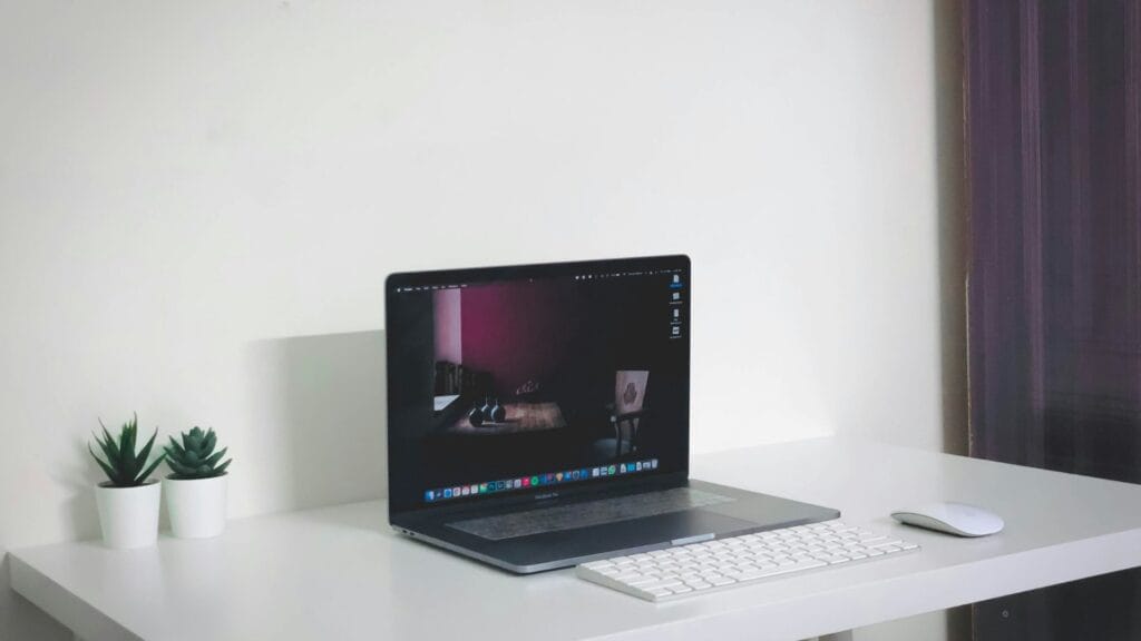 An image of a clear desk and workspace with just a laptop on it. Photo by Arvind Men.