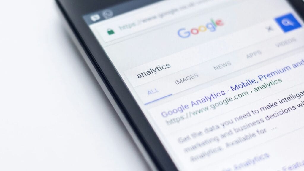 A close up of a phone on Google Search. AI search impact on websites. Photo by Edho Prata.
