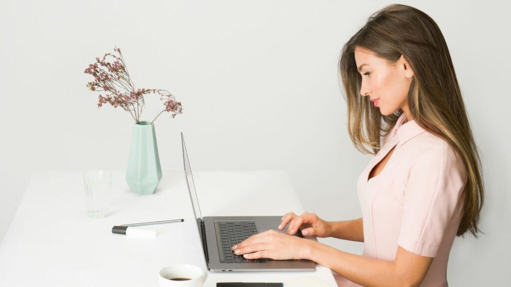 Woman confidently using her computer knowing how to get more enquiries from your website.