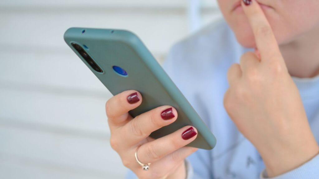 An image highlighting the simple business website benefits shown by someone looking at a phone and being confused. 