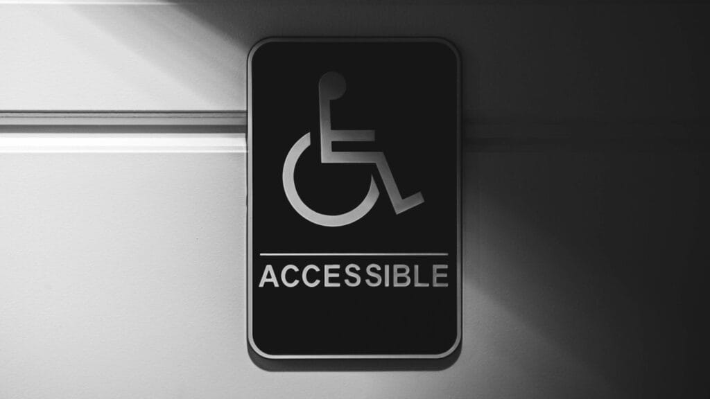 An image of a disabled accessible sticker hanging on a door. Photo by Erik Mclean.
