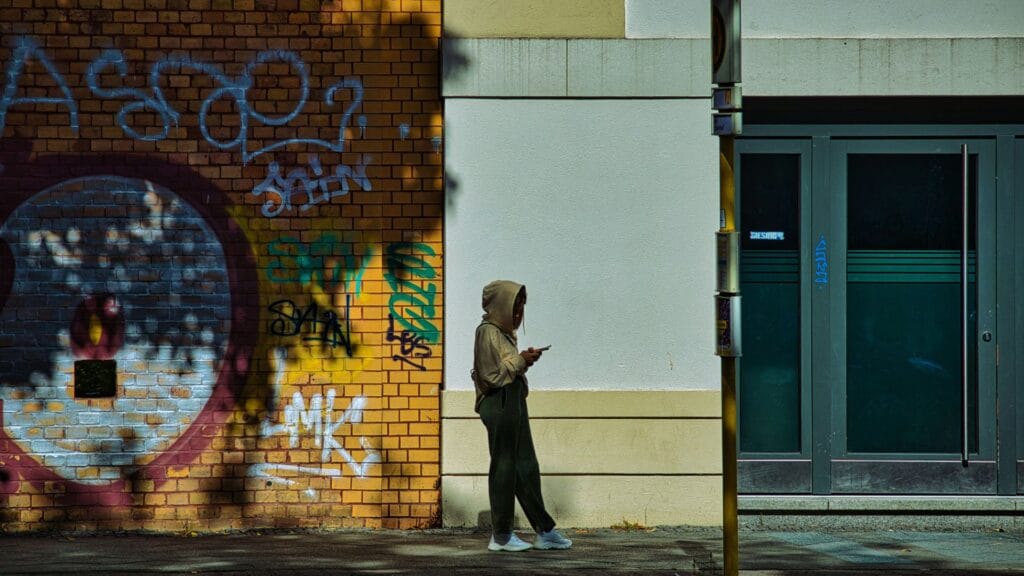Urban landscape with a person simply using their mobile phone. Photo by Moises Gonzalez. 